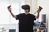 Boy playing video game with VRS goggles in living room