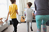 Mother and sons exercising in living room