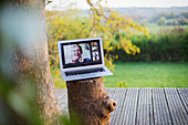 Friends video chatting on laptop screen on idyllic balcony