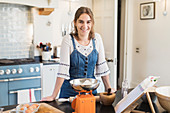 Portrait confident teenage girl baking in kitchen