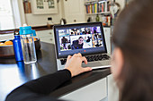 Woman taking online exercise class at laptop