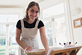Portrait smiling teenage girl baking in kitchen