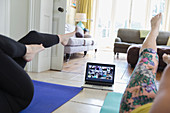 Women exercising at home online with laptop