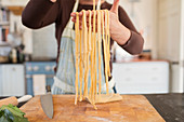 Close up woman making fresh homemade pasta in kitchen