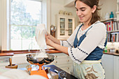 Teenage girl measuring flour for baking in kitchen