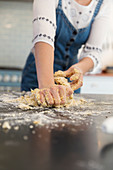Teenage girl kneading dough on kitchen counter