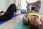 Mother and daughter exercising online at home with laptop