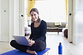 Smiling teenage girl practicing online yoga at home