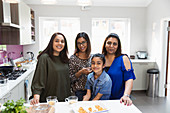 Portrait happy Indian women cooking in kitchen