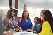 Indian women and girls talking in kitchen