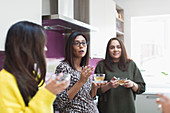 Women talking and drinking tea in kitchen