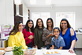 Portrait happy Indian women and girls cooking in kitchen