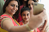 Happy Indian women in bindis and saris taking selfie