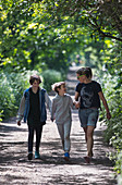 Mother and sons walking on sunny park path