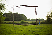 Branch frame over woman walking in idyllic grass field