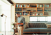 Man reading book in modern living room