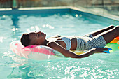 Serene young woman laying on inflatable raft