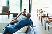 Father and daughter talking on living room sofa