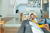 Young woman with remote control watching TV