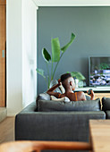Young woman with remote control watching TV