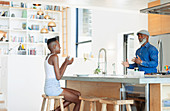 Father and daughter talking in modern kitchen
