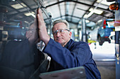 Male mechanic examining car in auto repair shop