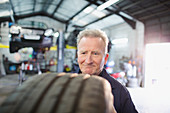 Male mechanic examining tire in auto repair shop