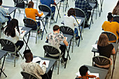 High school students taking exam at tables