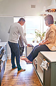 Mature couple emptying garbage in kitchen