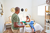 Happy couple folding laundry and relaxing on bed