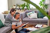 Affectionate couple reading in living room