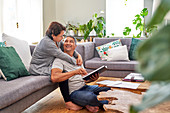 Mature couple reading and talking in living room