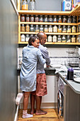 Happy Wife hugging husband doing dishes