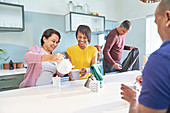 Happy women friends enjoying tea in kitchen