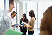 Business people reviewing paperwork in office