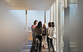 Business people talking at sunny office window