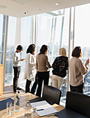 Business people talking at conference room window