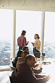 Business people talking at highrise office window