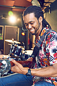 Male musician playing guitar in recording studio