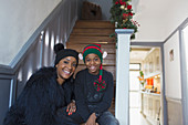 Mother and son wearing Christmas hats on staircase