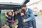 Happy family with Christmas tree in car