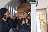 Happy mother and son in Christmas hat on stairs