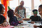 Father serving Christmas cake to family at table