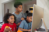 Brothers and sister using computer