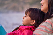 Close up daughter relaxing on mother at beach