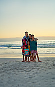 Portrait affectionate family on sunset ocean beach