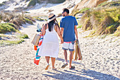 Affectionate couple walking on sunny beach path