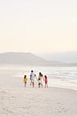 Family walking on ocean beach, South Africa