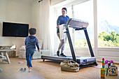 Boy playing while mom exercises on treadmill
