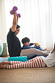 Mother exercising with dumbbells with kids